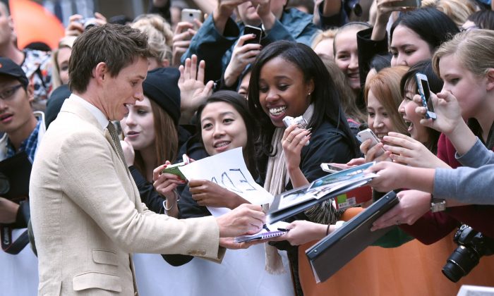 Eddie Redmayne signs autographs as he attends a premiere for "The Danish Girl" on day 3 of the Toronto International Film Festival at the Princess of Wales theatre on Saturday, Sept. 12, 2015, in Toronto. (Photo by Evan Agostini/Invision/AP)